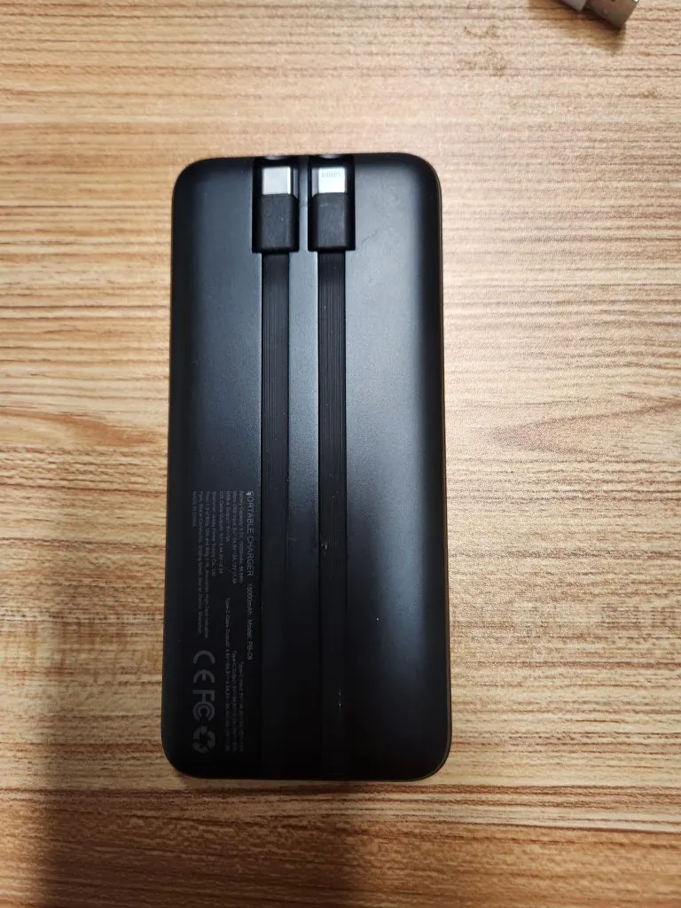 The power bank with its two built-in cables extended, USB-C and Lightning